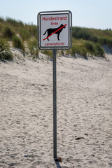 Am Strand, Hundestrand an der Ostsee steht ein Schild welches den Bereich des Hundestrandes markiert.