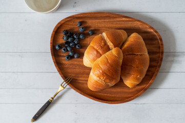 There are three pieces of bread in the wooden plate