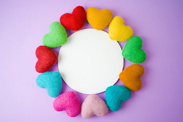 Valentines day concept with rainbow heart shapes on purple background with copy space. Top view