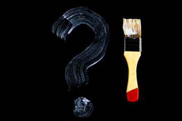 Question mark painted on a black background. White question mark.