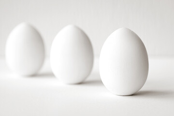 Three white eggs on a white background