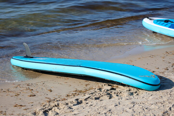 Details eines am Strand liegenden Standpaddel Brett. Stand Up Paddle Board.
