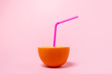 The concept of fresh natural orange juice. Sliced orange on a pink background. refreshing drink