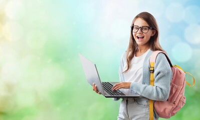 Portrait of smiling teen girl using a laptop computer, studying online
