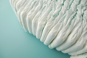 stack of baby diaper on light green background 