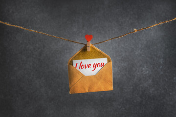an envelope with a message i love you hanging on a rope
