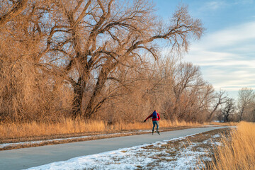 senior male with backpack is inline skating on a paved bike trail along Poudre River in Colorado,...