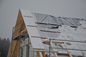 Bad news for builders, stop work on building a house due to heavy snowfall.snow covered truss and...