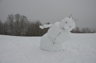 The big snowman has a tilted body that looks like he's falling. has ski poles and cross-country...
