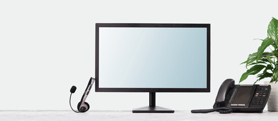 Computer monitor mockup for your design and VOIP headset phone on desk at modern office....