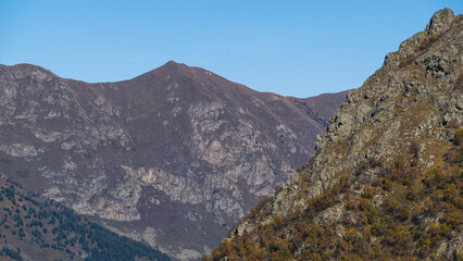 The rocks are brown. The Caucasus Mountains in North Ossetia. Landscape in the mountains and blue sky with clouds