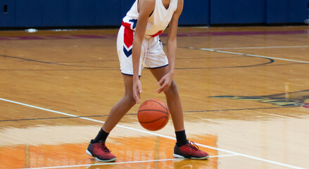 Fototapeta premium High school basketball player dribbling the ball during a game