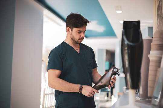 A Young Orthopedist Placing A Knee Prosthesis On A Shelf.bionic Legs.