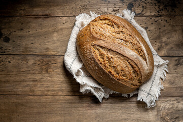 Freshly homemade baked rye bread on wooden background.