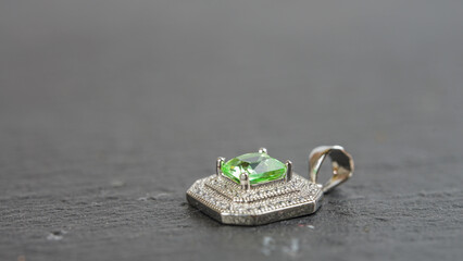 Expensive pendant with a diamond. Beautiful design pendant with green gemstones.
