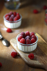 Italian dessert panna cotta with raspberries on wooden background. 