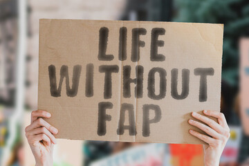 The phrase " Life without fap " on a banner in men's hand with blurred sea on the background. Impotence. Intensity. Energy. Strength. Muscle. Marriage. Strong. Health care. Self abuse. Dependency