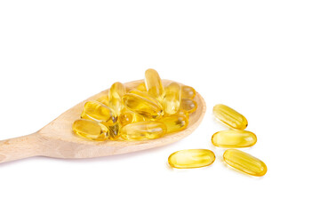 Pile of softgels capsules Omega 3 in wooden spoon isolated on white background. Close up with copy space