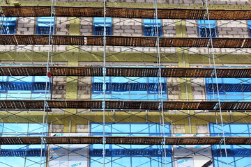 building construction finishing works on the facade scaffolding