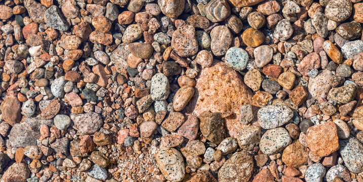 Colorful river peebles texture background. Small wet stones texture. Natural mineral wallpaper.