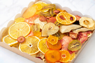 various multi-colored dry fruits in a kraft box, top view