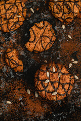 Sweet round cookies with sunflower seeds and chocolate on a dark background.