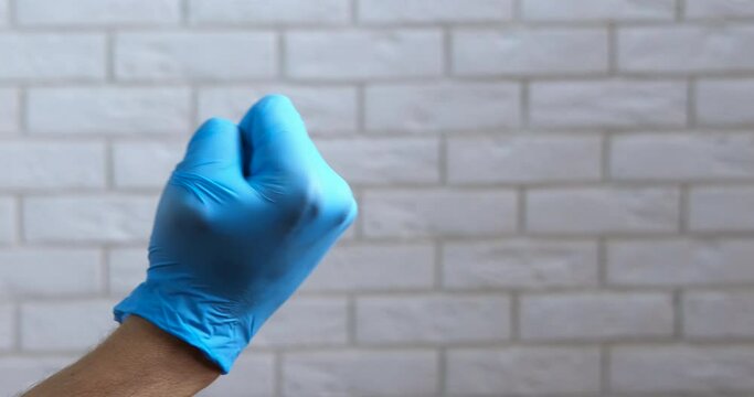 Angry woman show fuck. Angry medical worker in blue latex glove show the middle finger in the hospital.