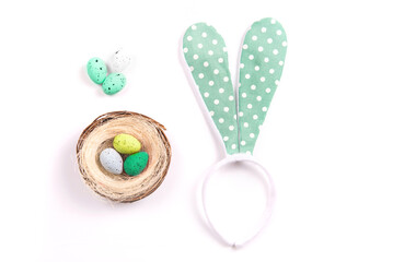 Colorful decorations with Easter egg nest and rabbit ears on white background. copy space, top view