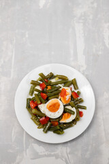 salad green beans, pepper and boiled eggs on plate