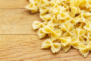 Heap of raw farfalle italian pasta on wooden table