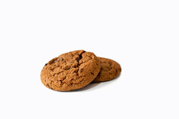 Two homemade chocolate chip cookies on a white background. American chocolate chip cookie lies on a white background. Delicious sweet breakfast with coffee or milk