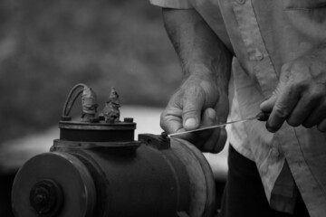 Men's hands, in the summer at the cottage, on a grinding machine sharpen a knife. Banner, cover, flyer, layout design