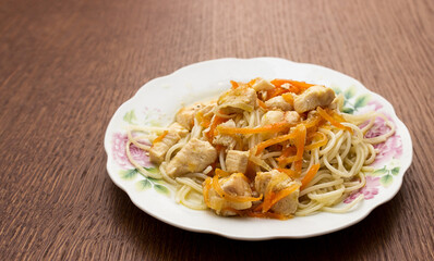 spaghetti with meat and vegetables on a white plate
