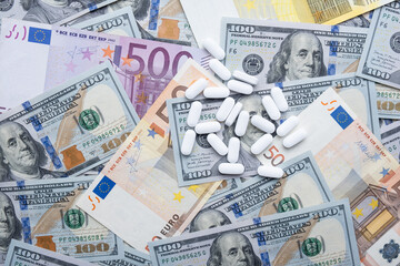 Pills on the background of the dollar and the euro close-up.