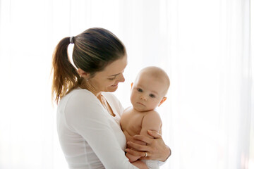 Mother, holding her sick baby boy, sad baby, isolated on white