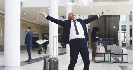 Big effort, big results. 4k video footage of a mature businessman throwing his paperwork in the air after receiving good news on his smartphone.