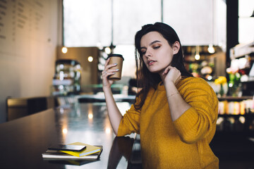 Dreamy woman with cardboard cup of coffee