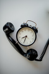 Old-fashioned clock and old phone handset from above.