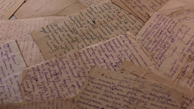 Table covered with many old letters. Left to right panoramic view with selective focus