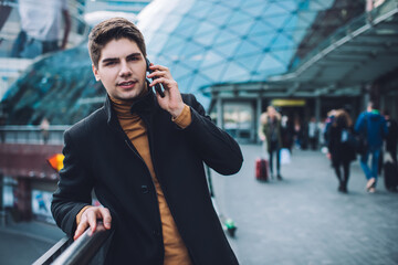 Stylish businessman talking on smartphone outside