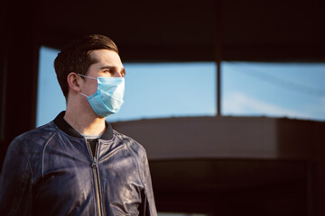 Close up portrait of man in blue protective mask standing on the street.