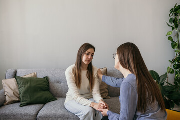 the psychologist woman put her hand on the shoulder of the upset woman patient. A gesture of support. Psychological assistance to a woman