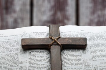 Old wooden Christian cross on Bible book