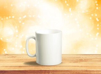 Obraz na płótnie Canvas White mug on a wooden background with bright lights in the background. New Year and Christmas.