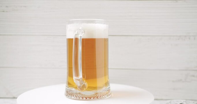 Craft Beer into the large glass. Beer Mug. On a white background. Half a liter, close up. Rotation 360 degrees. Glass full of beer ready to drink. 