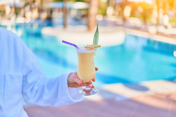 Relaxing summer vacations with refreshing pina colada cocktail by the pool at the all-inclusive...