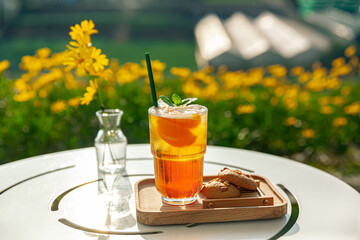 fresh homemde peach ice tea with mint, chocolate chip cookie served on table outdoors. summer cold...