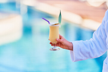 Relaxing summer vacations with refreshing pina colada cocktail by the pool at the all-inclusive...