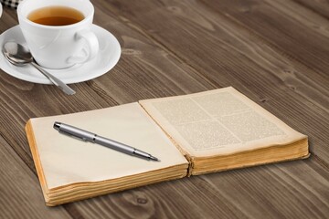 blank antique journal with paper pages with a stylish pen and cup of tea