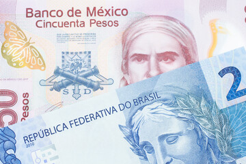 A macro image of a pink, plastic fifty peso bank note from Mexico paired up with a blue two real bank note from Brazil.  Shot close up in macro.